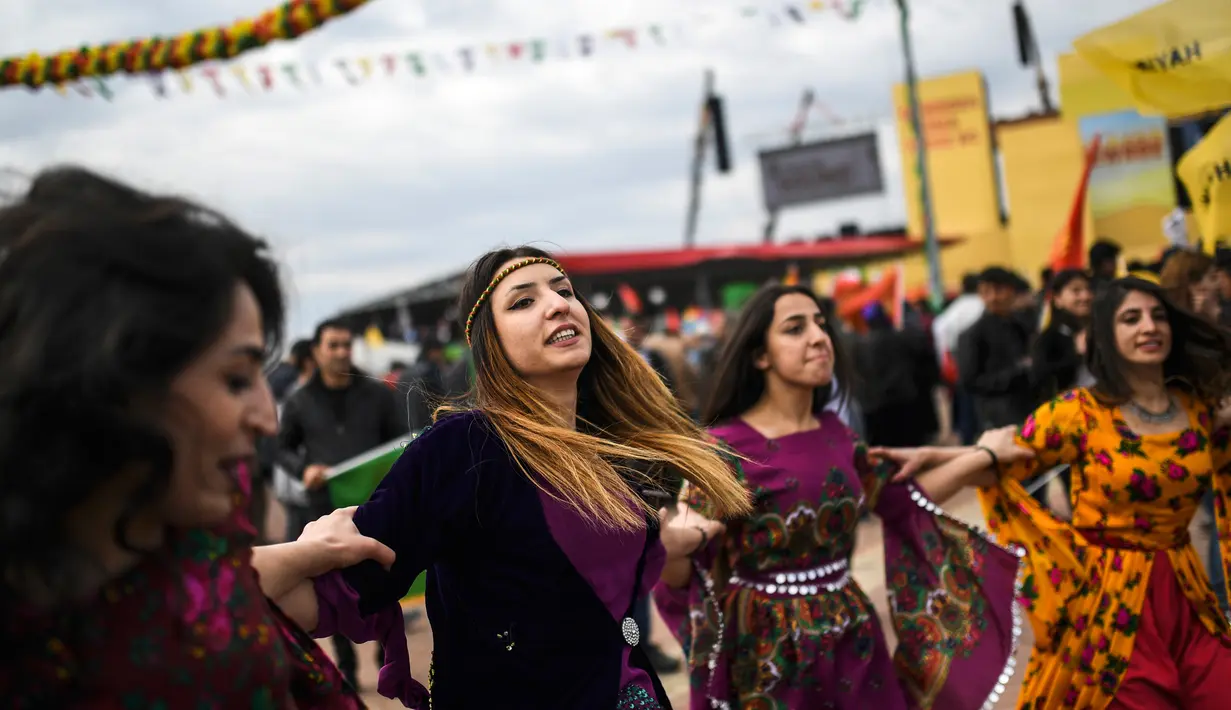 Sejumlah Wanita Kurdi Turki menari merayakan Perayaan Newroz di Diyarbakir, Turki (21/3). Festival ini dirayakan oleh orang-orang Kurdi yang tinggal di wilayah perbatasan Turki-Suriah. (AFP Photo / Ilyas Akengin)