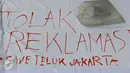 Spanduk penolakan reklamasi Teluk Jakarta saat aksi unjuk rasa di depan Balai Kota DKI Jakarta, Rabu (20/4). Unjuk rasa tersebut mendesak Ahok  untuk menghentikan proyek reklamasi di Teluk Jakarta dan penggusuran warga. (Liputan6.com/Immanuel Antonius)