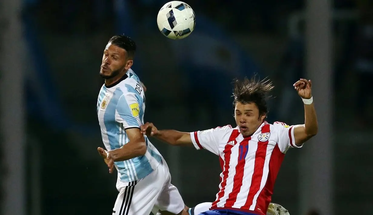 Perebutan bola antara pemain Argentina, Martin Demichelis, dan pemain Paraguay, Angel Romero, dalam laga Kualifikasi Piala Dunia 2018 zona Amerika Selatan, di Stadion Mario Kempes, Cordoba, Rabu (12/10/2016) pagi WIB. (Reuters/Marcos Brindicci)