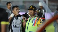 Striker Sriwijaya FC, Ferdinand Sinaga coba ditenangkan oleh Polisi Militer seusai pertandingan melawan Persija Jakarta yang berakhir 0-1 di Stadion Kanjuruhan, Rabu (25/11/2015). (Bola.com/Kevin Setiawan)