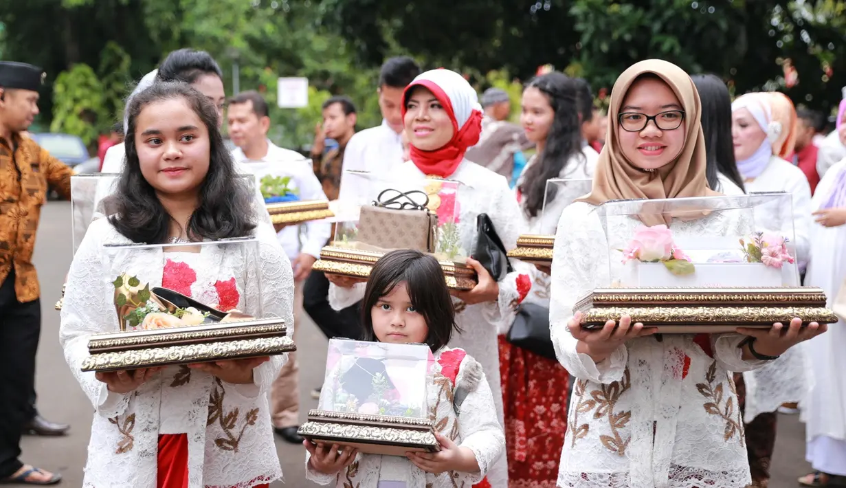 Keluarga besar Rifky kompak hadir dengan nuansa putih dan merah sambil membawa barang-barang seserahan untuk Biby. Sedangkan Rifky dan Arsen kompak dengan outfit paduan silver dan biru mudanya. (Adrian Putra/Bintang.com)