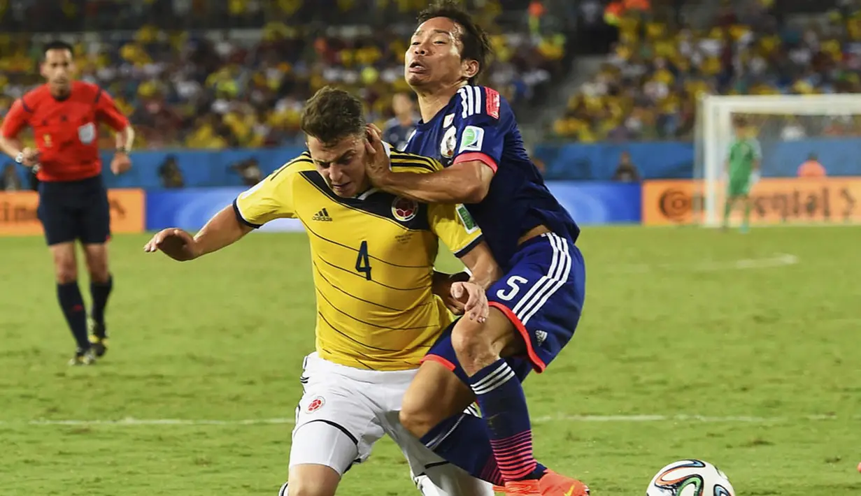 Santiago Arias (Kolombia - kiri) berebut bola dengan pemain belakang Jepang, Yuto Nagatomo, saat berlaga di penyisihan Piala Dunia Grup C di Stadion Pantanal, Cuiaba, Brasil, (25/6/2014). (REUTERS/Dylan Martinez)