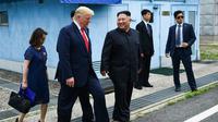 Presiden AS Donald Trump dan Pemimpin Korea Utara Kim Jong-un di sisi selatan garis demarkasi militer, zona demiliterisasi Korea (DMZ), Panmunjom pada Minggu 30 Juni 2019 (Brendan Smialowski / AFP PHOTO)