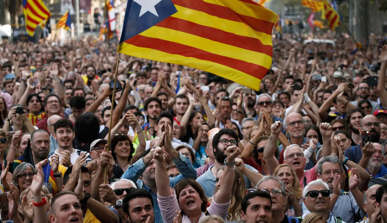 Sejumlah orang bereaksi ketika Parlemen Catalonia mendeklarasikan kemerdekaan dari Spanyol di luar gedung parlemen di Barcelona, Jumat (27/10). Sejumlah pendukung kemerdekaan, turun ke jalan dan menyanyikan lagu tradisional Catalan. (AP/Emilio Morenatti)