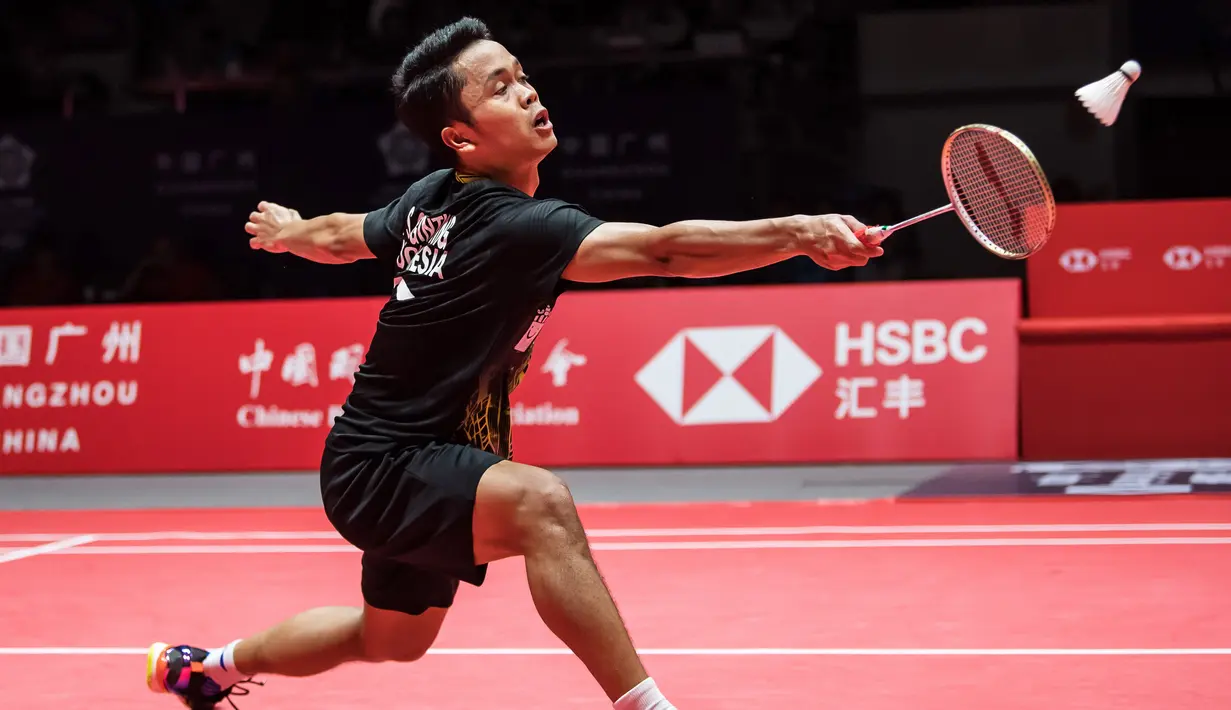 Tunggal putra Indonesia Anthony Sinisuka Ginting memukul kok ke arah Kento Momota dari Jepang pada laga final BWF World Tour Finals 2019 di Tianhe Gymnasium, Guangzhou, China, Minggu (15/12/2019).  Anthony Ginting gagal juara BWF World Tour Finals 2019 setelah takluk 21-17, 17-21, 14-21. (STR/AFP)