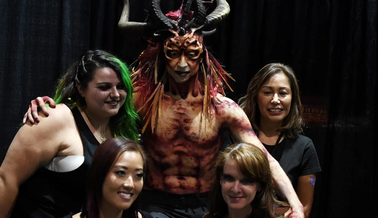 Make up artis berpose dengan model hasil riasannya saat acara ScareLA 'Monsters Come Together' di Los Angeles, California (6/8). Acara ini juga menjadi ajang berkumpulnya bagi para penggemar film horor. (AFP Photo/Mark Ralston)