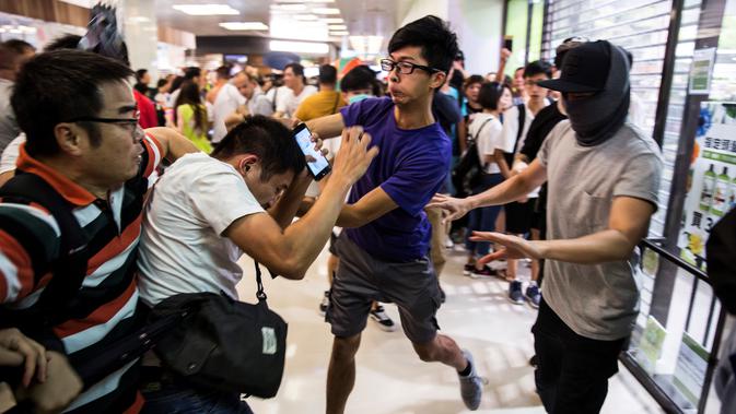 Demonstran pro-China (kiri) berkelahi dengan demonstran antipemerintah (kanan) di sebuah pusat perbelanjaan di Distrik Kowloon Bay, Hong Kong, Sabtu (14/9/2019). Bentrokan terbaru yang pecah di pusat perbelanjaan ini meluas ke jalanan di sekitarnya. (ISAAC LAWRENCE/AFP)
