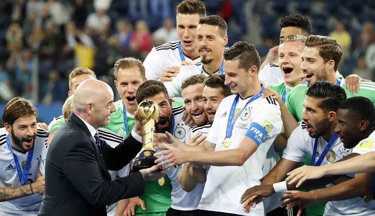 Presiden FIFA, Gianni Infantino, menyerahkan trofi Piala Konfederasi 2017 kepada kapten Jerman, Julian Draxler di Stadion Saint Petersburg, Rusia, Minggu (3/7/2017). Jerman menang 1-0 atas Cile. (EPA/Yuri Kochetkov)