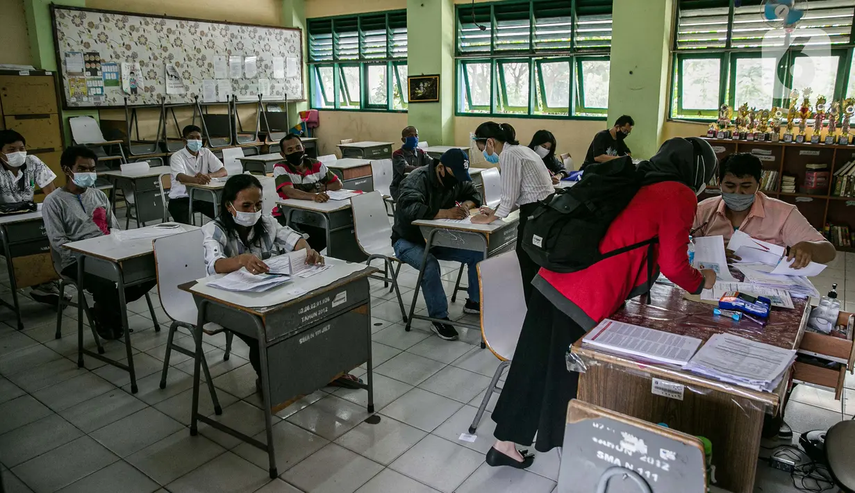 Warga menunggu untuk mengambil Bantuan Sosial Tunai (BST) di SMAN 111, Jakarta, Selasa (19/1/2021). Pemprov DKI Jakarta menyalurkan BST sebesar Rp 300 ribu kepada 1.055.216 KK mulai Januari hingga April 2021. (Liputan6.com/Faizal Fanani)