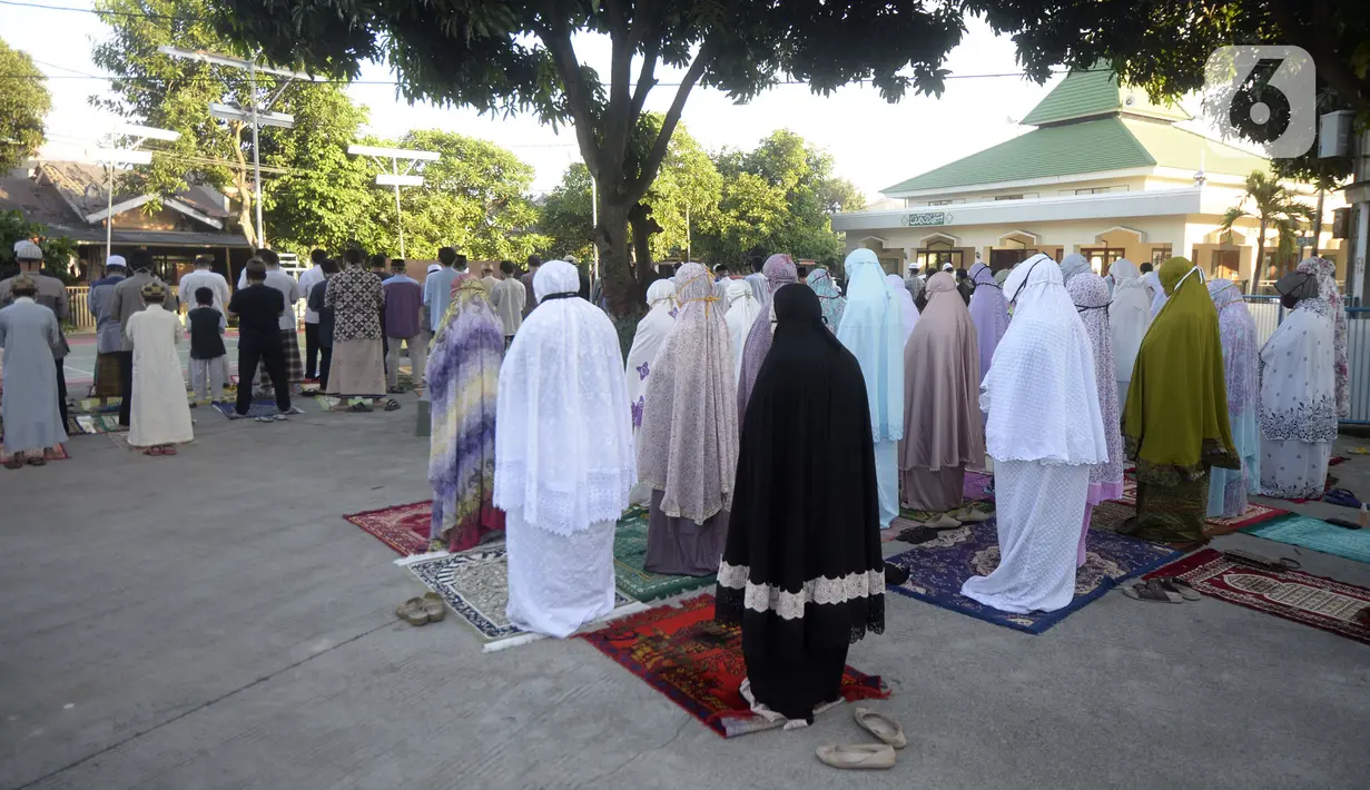Jemaah melaksanakan salat Idul Fitri di pelataran Masjid Al Kahfi Griya Pamulang 2, Parakan, Pamulang, Tangerang Selatan, Banten, Minggu (24/5/2020). Di tengah pandemi virus corona COVID-19, jemaah yang hadir mengenakan masker untuk mencegah penularan. (merdeka.com/Dwi Narwoko)