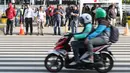 Warga bersiap melintasi Pelican Crossing di sekitar Halte Transjakarta GBK, Jakarta, Jumat, (30/11). Penyeberangan pelican crossing diberlakukan selama revitalisasi jembatan penyeberangan orang (JPO) berlangsung. (Liputan6.com/Helmi Fithriansyah)