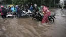 Para pengendara mendorong motornya yang mogok saat melintasi banjir di Jalan Boulevard Barat Raya, Kelapa Gading, Jakarta, Kamis (15/2). Hujan lebat mengguyur Jakarta sejak pagi hingga sore hari. (Liputan6.com/Arya Manggala)