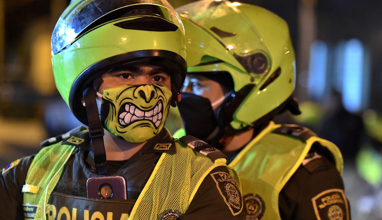 Petugas polisi menggunakan masker wajah sebagai langkah pencegahan terhadap penyebaran virus corona baru, COVID-19, di Cali, Kolombia pada 20 Maret 2020. Masker dijadikan masyarakat pilihan untuk mencegah penyebaran virus corona yang terus meningkat di seluruh dunia.  (Luis ROBAYO / AFP)