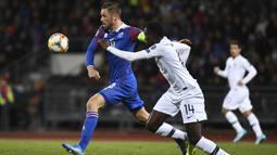 Gelandang Islandia, Gylfi Sigurdsson, berusaha melewati gelandang Prancis, Blaise Matuidi, pada laga Kualifikasi Piala Eropa 2020 di Reykjavik, Sabtu (11/10). Islandia kalah 0-1 dari Prancis. (AFP/Jonathan Nackstrand)
