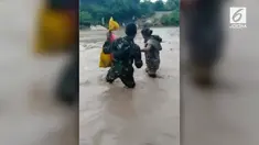 Aksi terpuji dilakukan tentara penjaga perbatasan Indonesia-Timor Leste, membantu warga melintasi sungai yang sedang meluap.