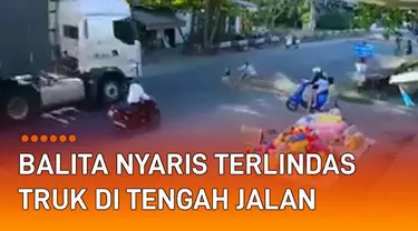 Seorang balita nyaris terlindas truk di tengah jalan mengundang perhatian.