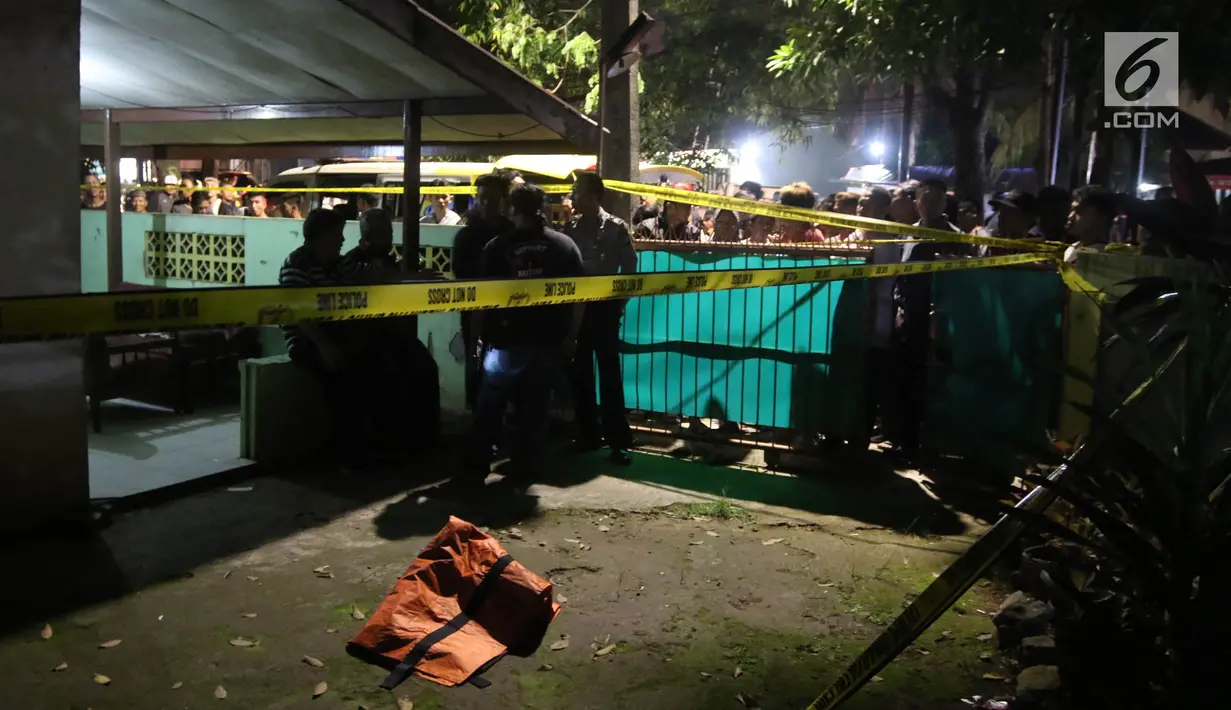 Polisi memasang garis polisi di lokasi  perampokan disertai pembunuhan di komplek TNI AL Pondok Labu, Jakarta, Kamis (5/4). Korban yang merupakan purnawirawan TNI AL tewas dengan 3 tusukan. (Liputan6.com/Arya Manggala)