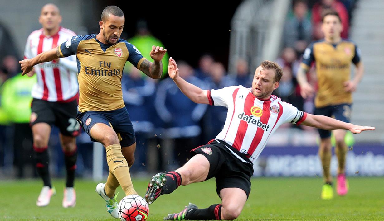 Pemain Arsenal, Theo Walcott (kiri), berebut bola dengan pemain Sunderland, Lee Cattermole, dalam laga Liga Inggris di Stadium of Light, Sunderland, Minggu (24/4/2016) malam WIB. (AFP/Graham Stuart)