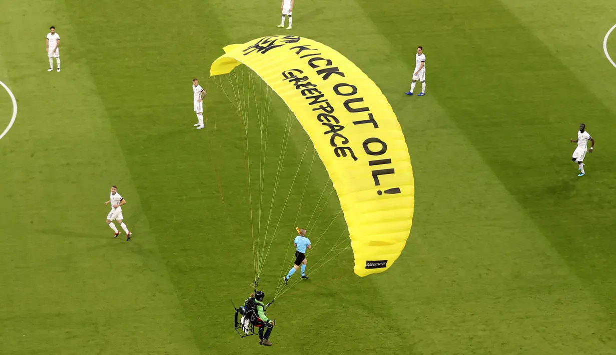 Di parasut kuning ciri khas Greenpeace saat melakukan aksi tertulis "Kick Out Oil! Greenpeace". (Foto: AP/Pool/Alexander Hassenstein)