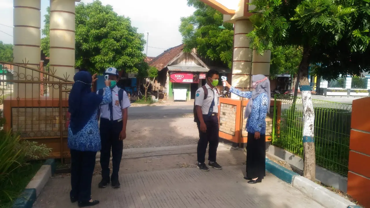 Para siswa dicek suhu tubuh sebelum masuk di kelasnya masing-masing. (Liputan6.com/Ahmad Adirin)