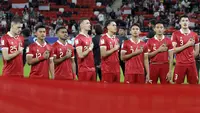 Para pemain starting XI Timnas Indonesia berbaris menyanyikan lagu kebangsaan Indonesia Raya sebelum dimulainya laga pertama Grup D Piala Asia 2023 Qatar menghadapi Timnas Irak di Ahmad bin Ali Stadium, Al-Rayyan, Doha, Senin (15/1/2024). (AFP/Karim Jaafar)