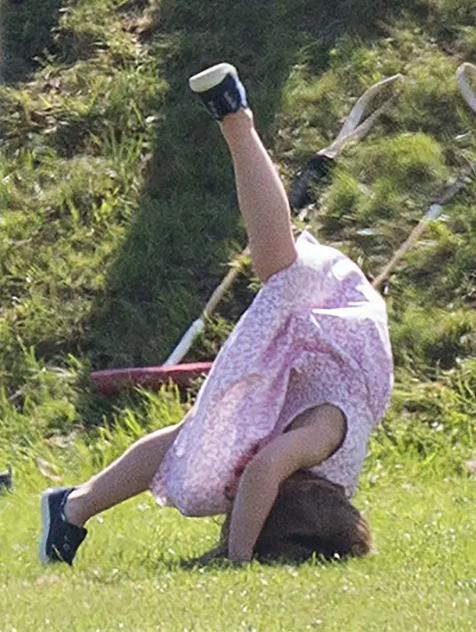 Putri Charlotte melakukan jungkir balik saat menghadiri acara amal bertajuk Maserati Royal Charity Polo Trophy di Beaufort Polo Club, Gloucestershire, Minggu (10/6). Charlotte terlihat lucu dan menggemaskan dalam balutan floral dress warna pink (AP Photo)