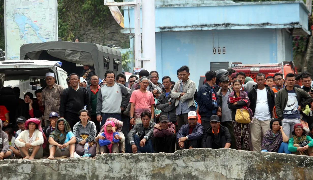 Kerabat penumpang menunggu proses pencarian yang dilakukan tim SAR terhadap korban tenggelamnya KM Sinar Bangun di pelabuhan feri Danau Toba, Sumatera Utara, Rabu (20/6). Hingga hari ketiga proses pencarian korban terus dilakukan. (AP/Binsar Bakkara)
