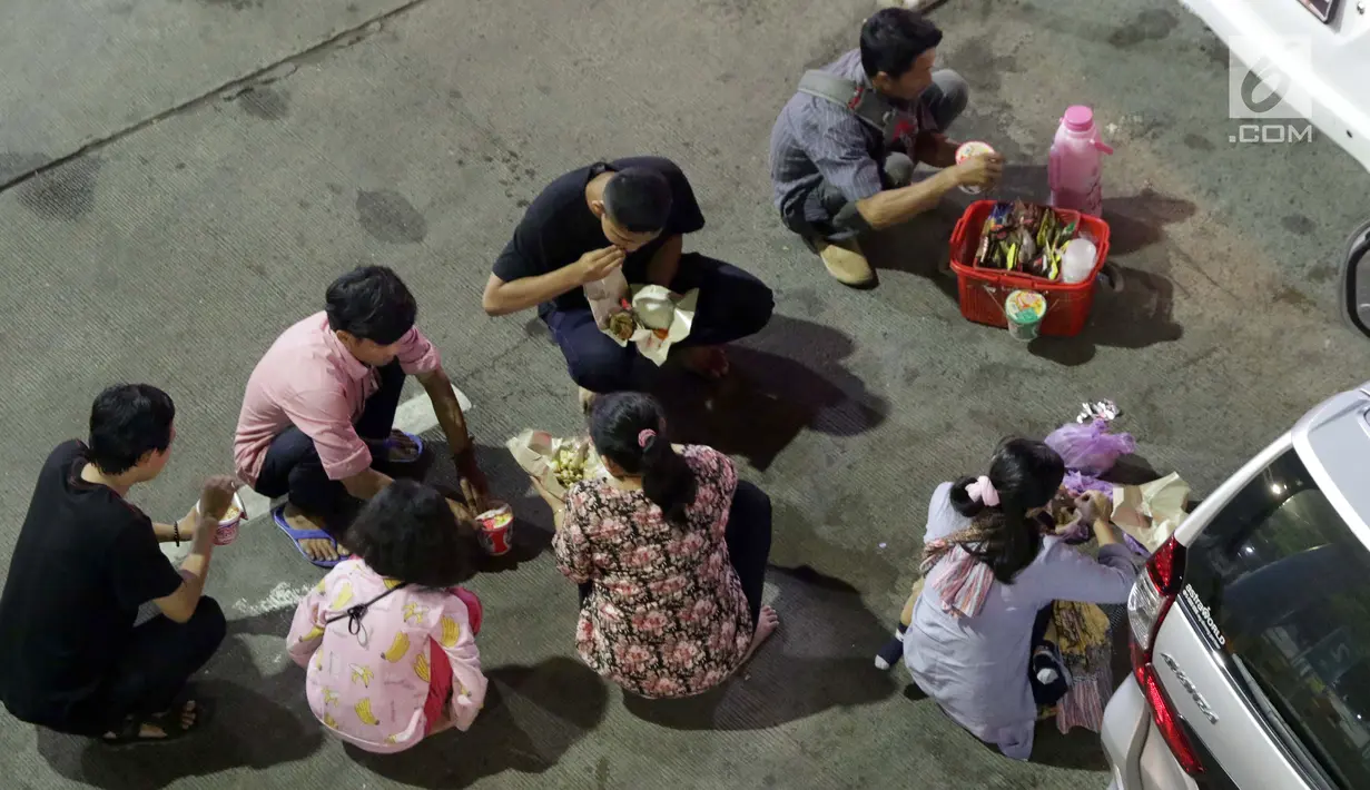 Pemudik makan bersama sambil menanti waktu masuk kapal di Dermaga II Pelabuhan Penyebrangan Merak, Banten, Senin (3/6/2019). Sambil menanti waktu bongkar muat kapal penyebrangan, pemudik memanfaatkan waktu untuk makan bersama. (Liputan6.com/Helmi Fithriansyah)
