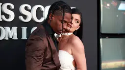 Travis Scott (kiri) berpose bersama Kylie Jenner saat menghadiri pemutaran perdana Netflix "Travis Scott: Look Mom I Can Fly" di Barker Hangar, Santa Monica, California, Amerika Serikat, Senin (27/8/2019). Scott dan Kylie tampak mesra di depan kamera. (Rich Fury/GETTY IMAGES NORTH AMERICA/AFP)