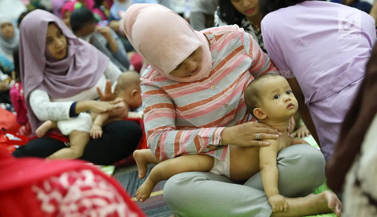 Para peserta mengikuti acara pijat massal bayi di Gedung Kementerian Kesehatan, Jakarta, Selasa (7/11). Acara tersebut digelar dalam rangka menyambut peringatan Hari Kesehatan Nasional ke-53. (Liputan6.com/Immanuel Antonius)