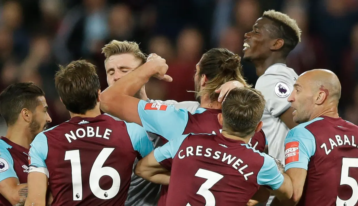 Pemain West Ham United dan pemain Manchester United terlibat saling dorong saat bertanding dalam Liga Inggris di London Stadium di London (10/5). Manchester United bermain imbang tanpa gol melawan West Ham United. (AP Photo / Alastair Grant)