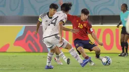 Pergerakan pemain Timnas Spanyol U-17, Quim Junyent (kanan) dibayangi dua pemain Jepang U-17 dalam pertandingan babak 16 Besar Piala Dunia U-17 di Stadion Manahan, Solo, Senin (20/11/2023). (Bola.com/Arief Bagus)