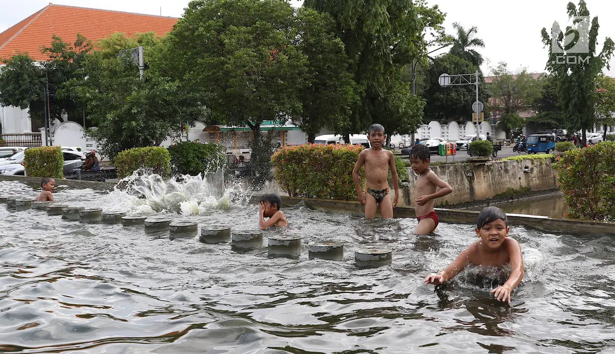 Anak-anak bermain di kolam air mancur penghias kawasan Pasar Baru, Jakarta, Selasa (29/1). Keterbatasan lahan bermain menyebabkan sebagian anak di Ibukota bermain tidak pada tempatnya, meskipun berbahaya bagi keselematan. (Liputan6.com/Immanuel Antonius)