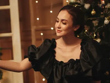 Menyambut perayaan Natal, Rianti Cartwright menjalani sebuah pemotretan. Ia tampak menawan dan simpel mengenakan dress berwarna hitam. Terlihat pula dekorasi pohon natal berwarna hijau dengan pernak-pernik meriah. (Liputan6.com/IG/@riantic)
