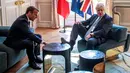 PM Inggris, Boris Johnson menaruh kaki di atas meja di depan Presiden Prancis Emmanuel Macron dalam kunjungan kenegaraan di Istana Elysee, Paris, Kamis (22/8/2019). Awak media mengabadikan momen ketika Johnson menumpangkan kakinya di meja kopi. (Christophe Petit Tesson, Pool via AP)