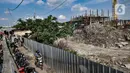 Warga melintas di dekat proyek Kampung Susun Akuarium, Penjaringan, Jakarta, Kamis (11/3/2021). Menurut Ketua RT Kampung Akuarium, Topas, mengungkapkan dua dari lima blok Kampung Susun Akuarium ditargetkan rampung pada Agustus 2021. (merdeka.com/Iqbal S. Nugroho)