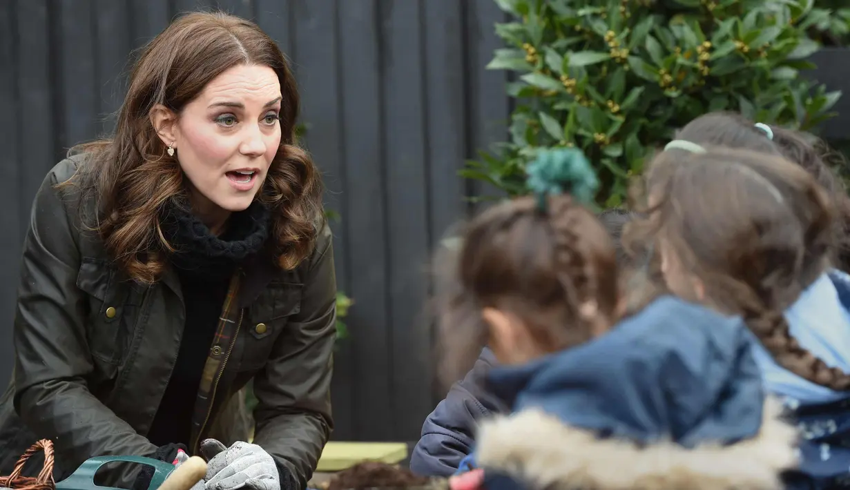 Ekspresi Kate Middleton saat berbincang dengan anak-anak Sekolah Dasar Robin Hood di London, Inggris (29/11). Kedatangan Kate Middleton untuk merayakan sepuluh tahun Kampanye The Royal Horticultural Society (RHS). (AFP Photo/Pool/Eddie Mulholland)