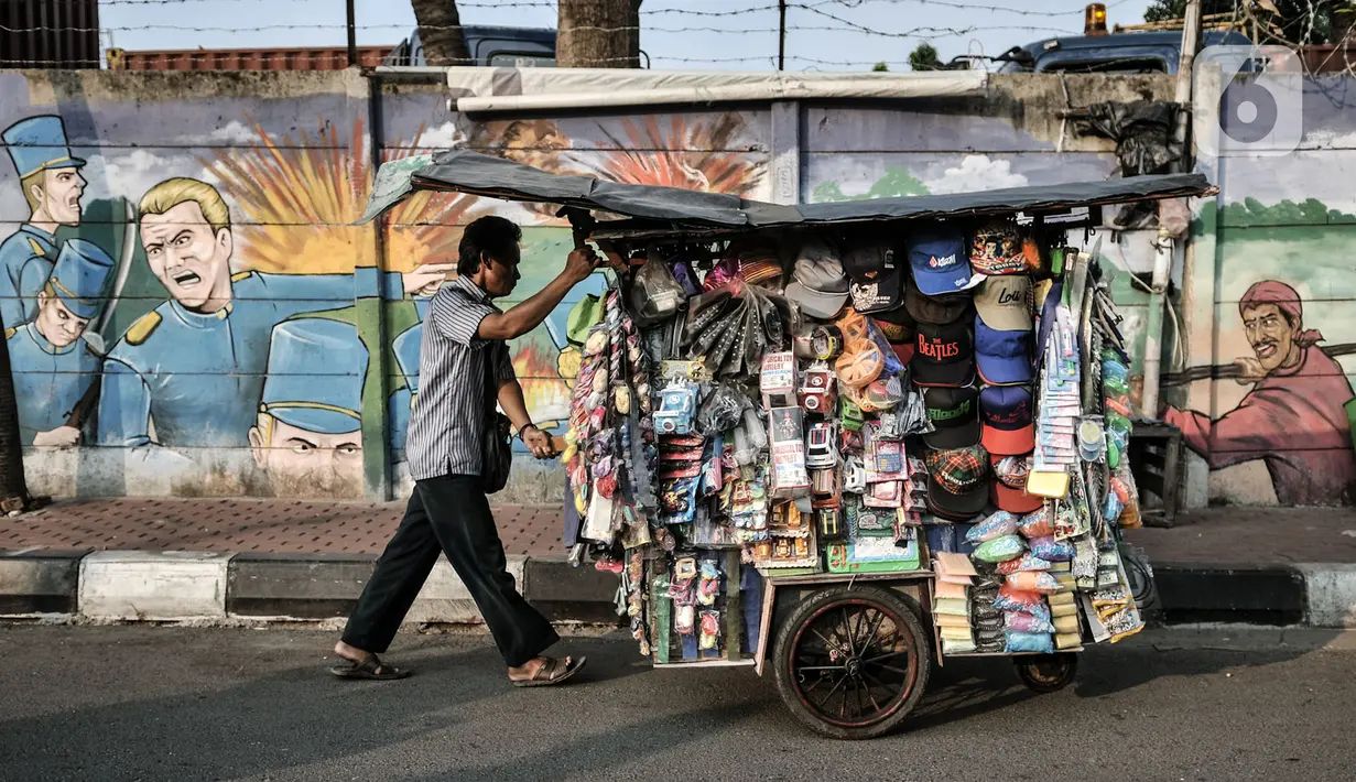 Pedagang melintasi mural bertemakan perjuangan Kemerdekaan Republik Indonesia di Jalan Pluit Raya III, Jakarta, Senin (10/8/2020). Mural itu diharapkan menjadi media agar masyarakat selalu mengingat sejarah dan menghargai jasa para pahlawan dalam memerdekakan Tanah Air. (merdeka.com/Iqbal Nugroho)