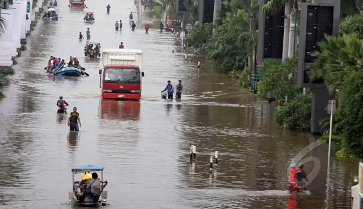 Masyarakat menggunakan delman saat melewati banjir di kawasan Kelapa Gading, Jakarta, Selasa (10/2). Selain perahu karet, kendaraan ini juga bermanfaat untuk para pengais rezeki ditengah bencana banjir yang melanda Ibukota. (Liputan6.com/Faizal Fanani)