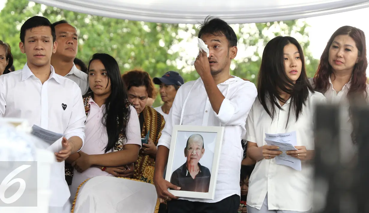 Artis Ruben Onsu didampingi Sarwenda menyeka airmatanya saat prosesi pemakaman sang ayah, Johannes Abraham Onsu di TPU Pondok Ranggon, Jakarta Timur, Rabu (1/2). Ayah Ruben dan Jordi Onsu menghempuskan napas di usia 74 tahun (Liputan6.com/Herman Zakharia)