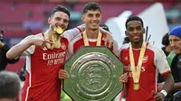 Tiga rekrutan anyar Arsenal, Declan Rice, Kai Havertz, dan Jurrien Timber, berfoto bersama trofi Community Shield yang diraih The Gunners setelah mengalahkan Man City di Stadion Wembley, Minggu (6/8/2023). (JUSTIN TALLIS / AFP)