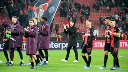 Pelatih Bayer Leverkusen, Xabi Alonso, bersama anak asuhnya memberikan aplaus kepada suporter setelah laga melawan Molde FK pada matchday 6 Grup H Liga Europa 2023/2024 yang digelar di BayArena, Jumat (15/12/2023). Pelatih asal Spanyol ini sukses memoles Bayer jadi tim yang berbahaya meski tanpa pemain bintang. (AFP/Ulrich Hufnagel)