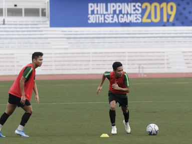 Pemain Timnas Indonesia U-22, Syarian Abimanyu dan Evan Dimas, bersiap melakukan tendangan bebas saat latihan di Stadion Rizal Memorial, Manila, Senin (25/11). Latihan ini persiapan jelang laga SEA Games 2019 melawan Thailand. (Bola.com/M Iqbal Ichsan)