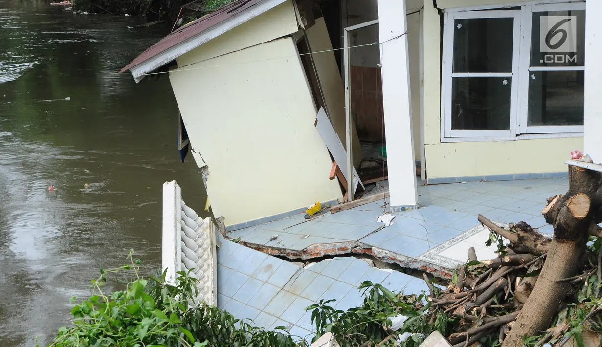 Kondisi bangunan rumah yang amblas akibat longsor di bantaran Kali Ciliwung, Kelurahan Bidara Cina, Jakarta Timur, Senin (19/3). Terdapat dua bangunan yang terdampak longsor, yaitu rumah dan indekos. (Liputan6.com/Herman Zakharia)