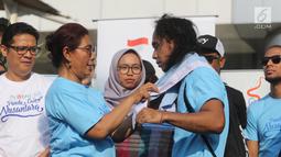 Menteri Kelautan dan Perikanan Susi Pudjiastuti memasangkan syal ke Kaka Slank saat meresmikan  'Pandu Laut Nusantara' sebagai wadah bersama untuk para pemerhati laut di CFD kawasan Bundaran HI, Jakarta, Minggu (15/7). (Liputan6.com/Arya Manggala)