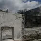 Gunung Sinabung terlihat dari puing rumah yang rusak akibat luncuran awan panas pada April 2015 di Desa Sibintun, Karo, Sumatera Utara, Minggu (5/7/2015). Akibat letusan Sinabung, desa tersebut sudah tak lagi berbentuk. (Liputan6.com/Johan Tallo)