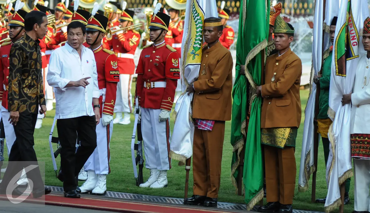 Presiden Joko Widodo dan Presiden Rodrigo Duterte berjalan menuju Istana Negara, Jakarta, Jumat (9/9). Duterte memilih Indonesia sebagai tujuan pertama kunjungan kenegaraannya. (Liputan6.com/Faizal Fanani)