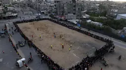 Pemuda Palestina bermain sepak bola di kamp pengungsi sebelum berbuka puasa selama bulan suci Ramadhan di Rafah, di Jalur Gaza selatan (11/4/2022). Sepanjang bulan, umat Islam yang taat harus berpantang dari makanan dan minuman dari fajar hingga matahari terbenam. (AFP/Said Khatib)