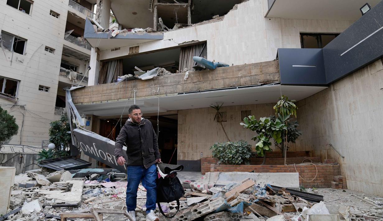 Israel dalam beberapa hari terakhir terus melancarkan serangan udara berturut-turut di wilayah selatan Lebanon. Tampak dalam foto, seorang pria membawa barang-barangnya saat meninggalkan hotel yang rusak akibat serangan udara Israel di Hazmieh, sebelah timur Beirut, Lebanon, Rabu 4 Maret 2026. (AP Photo/Hussein Malla)