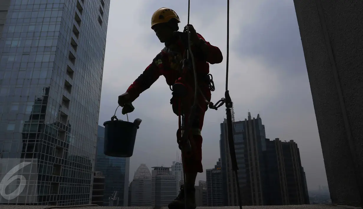 Bergelantungan di ketinggian gedung pencakar langit, tak menyurutkan semangat Sabar meski hanya menggunakan kaki satu, pria anak satu itu tetap semangat membersihkan kaca-kaca yang berselimutkan debu. (Liputan6.com/Angga Yuniar)